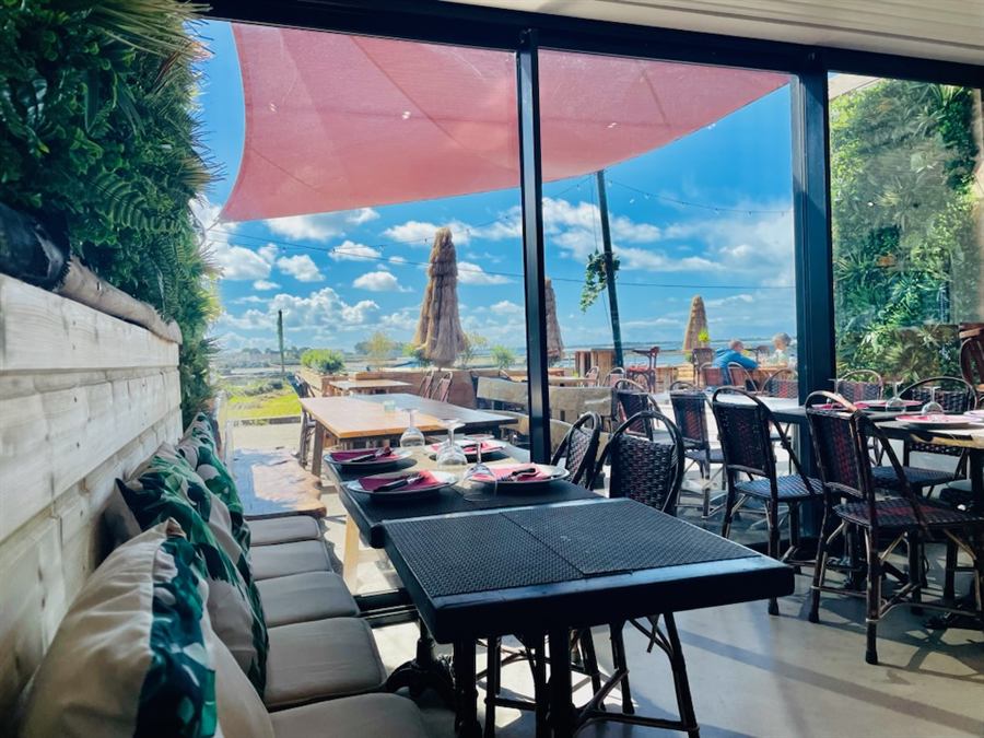 Salle intérieure avec vue sur la terrasse et la baie